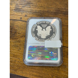 Silver coin in a protective case with a holographic label on a wooden surface